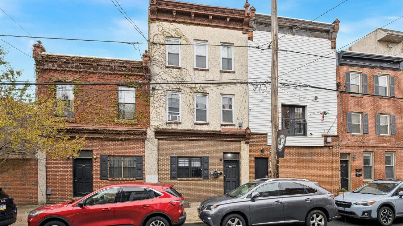 Row of urban brick buildings with cars.