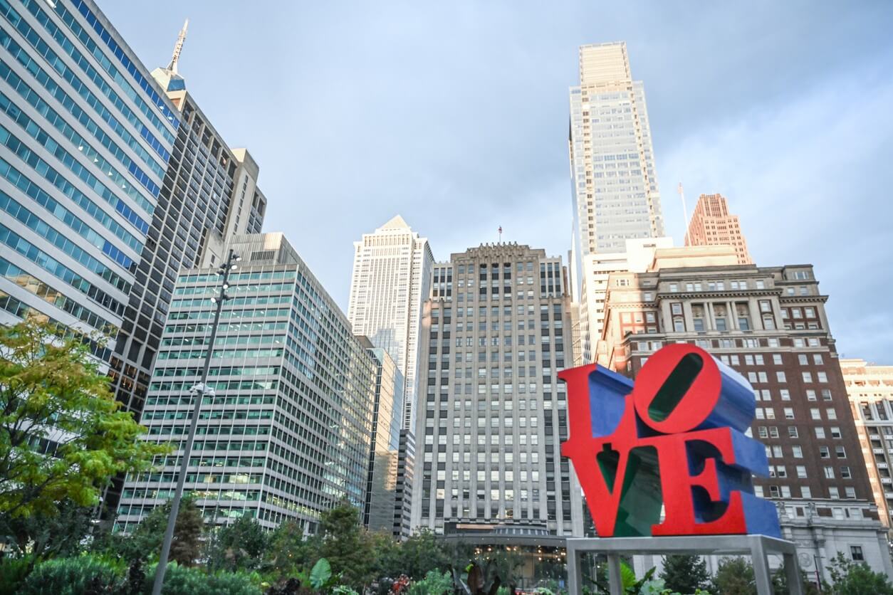 LOVE sculpture with city skyline background.