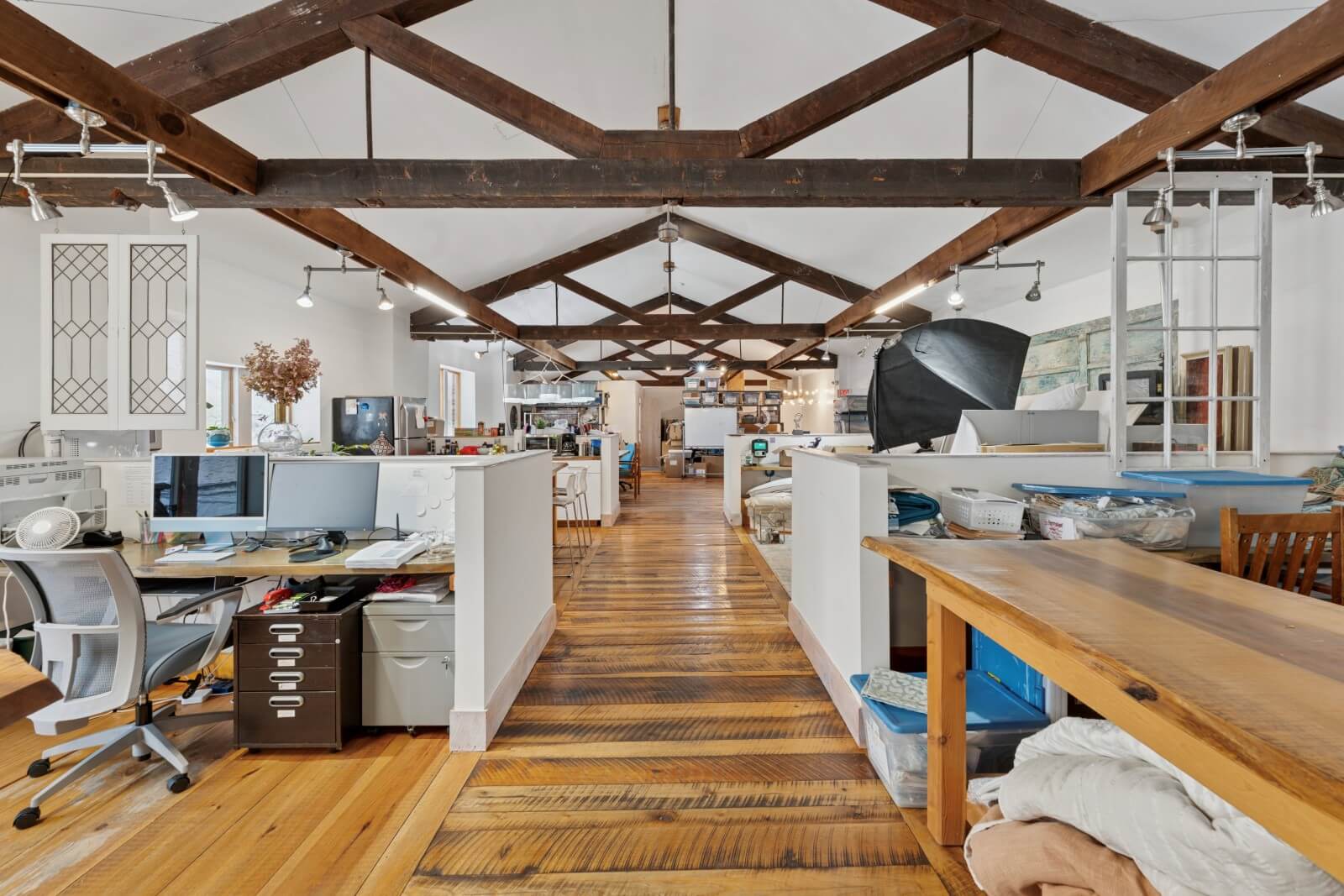 Spacious office with rustic wooden beams.