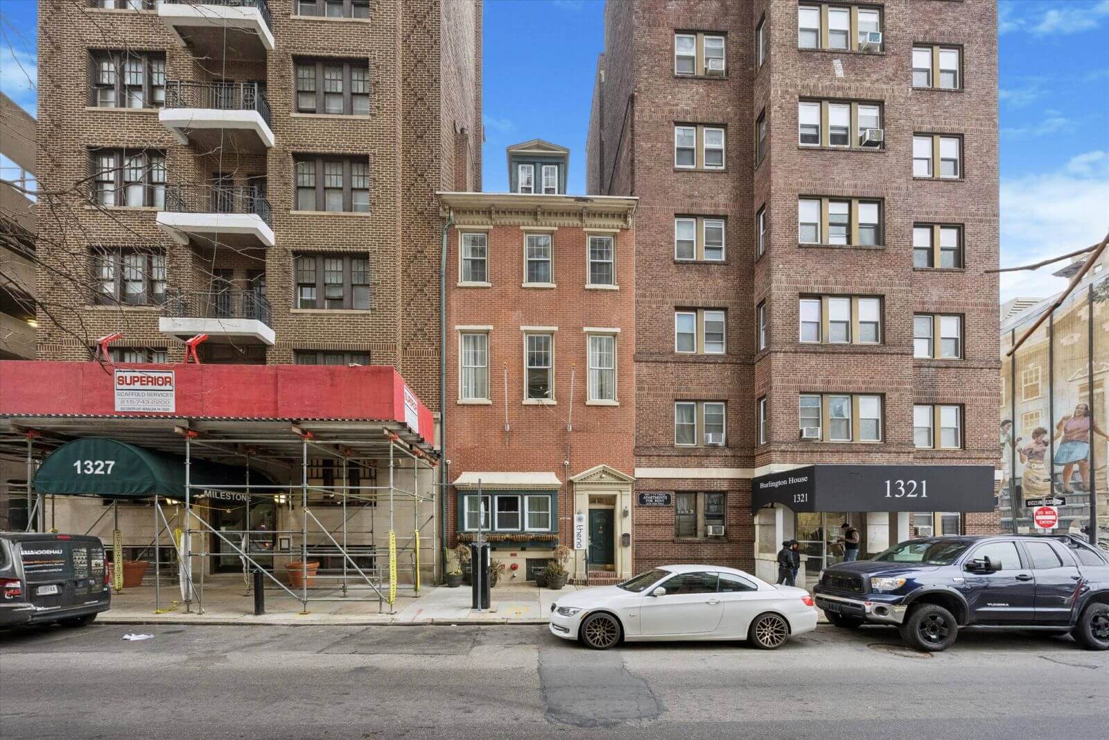 Street with buildings and parked cars.