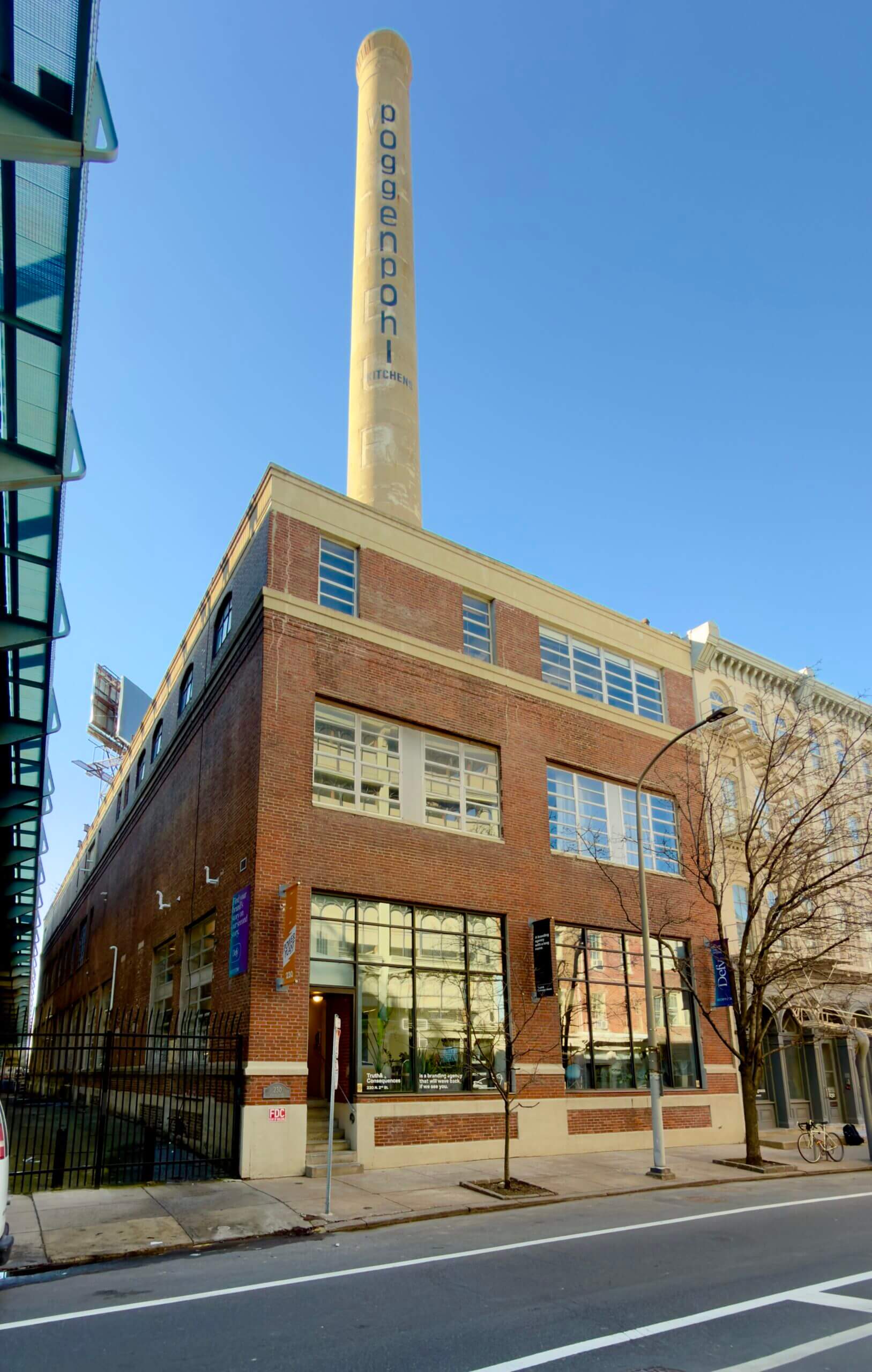 Historic brick building with tall smokestack.